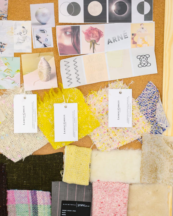 Color swatches and fabric samples arranged on a cork board with various design elements.